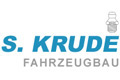 S. Krude Fahrzeugbau Logo mit blauem Text und einem kleinen grauen Fahrzeugsymbol auf weißem Hintergrund.