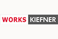 Logo mit dem Wort WORKS in Rot und KIEFNER in Weiß auf grauem Hintergrund.